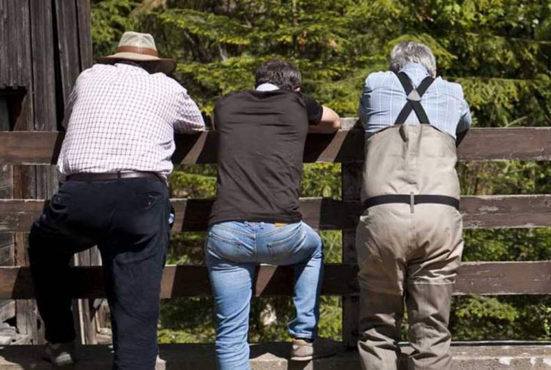 fishermen standing on a bridge 