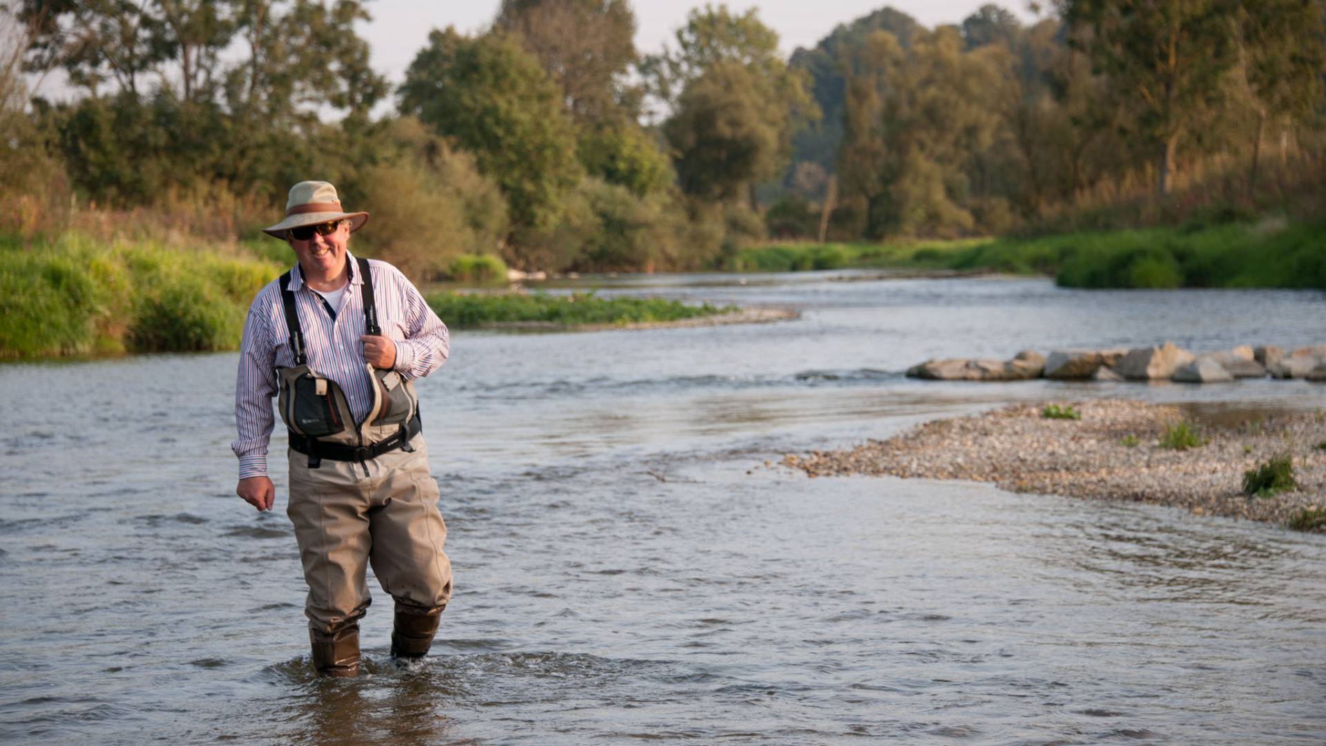 fisherman standing in a river 