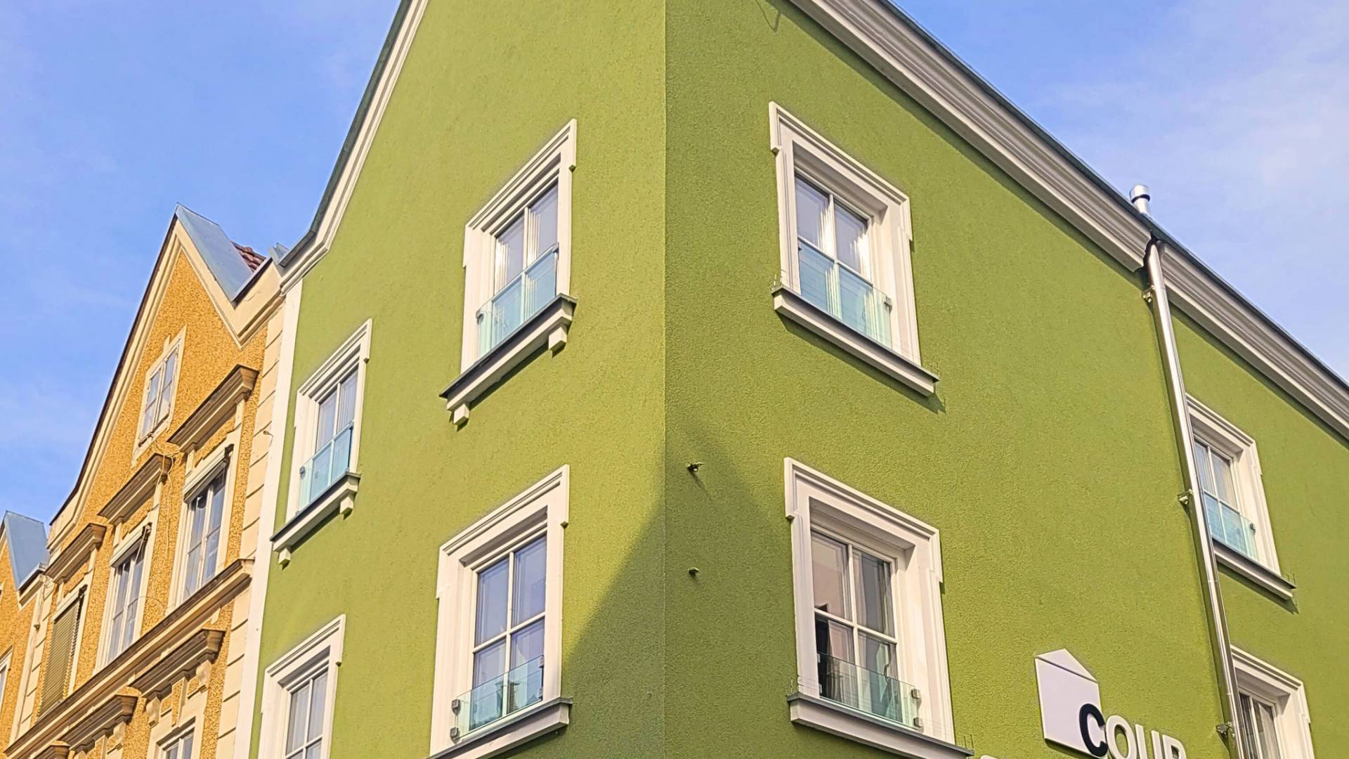 Green house facade with logo of Coup company